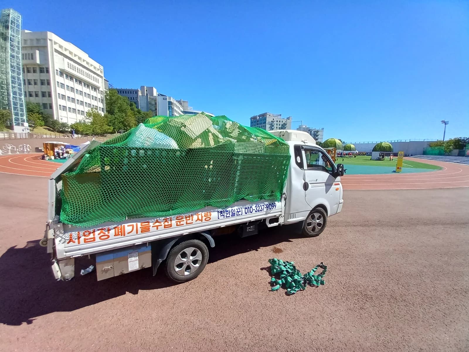 폐기물을 싣고 그물로 덮은 착한일꾼 사업장폐기물 수집운반 차량
